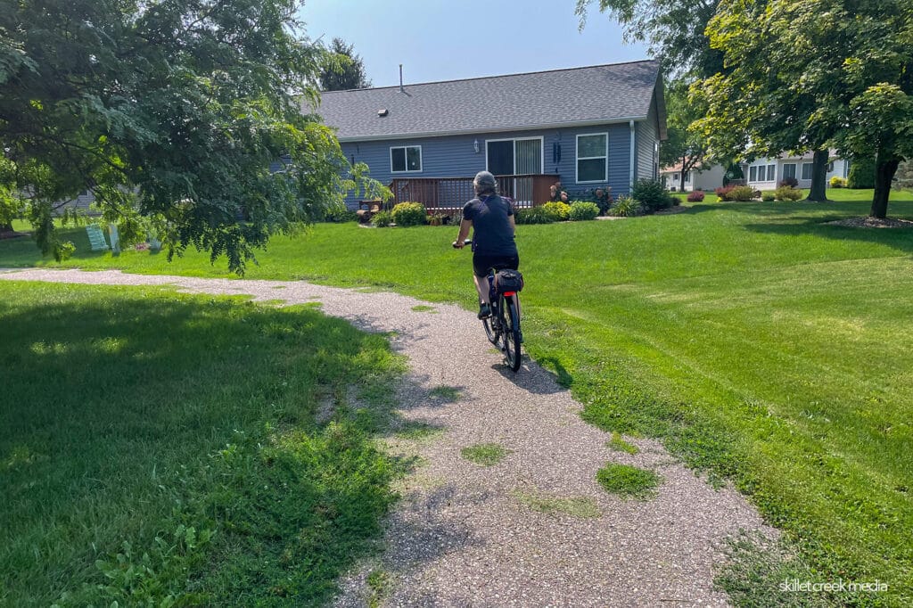 Riding through a housing development. Trail is overgrown.